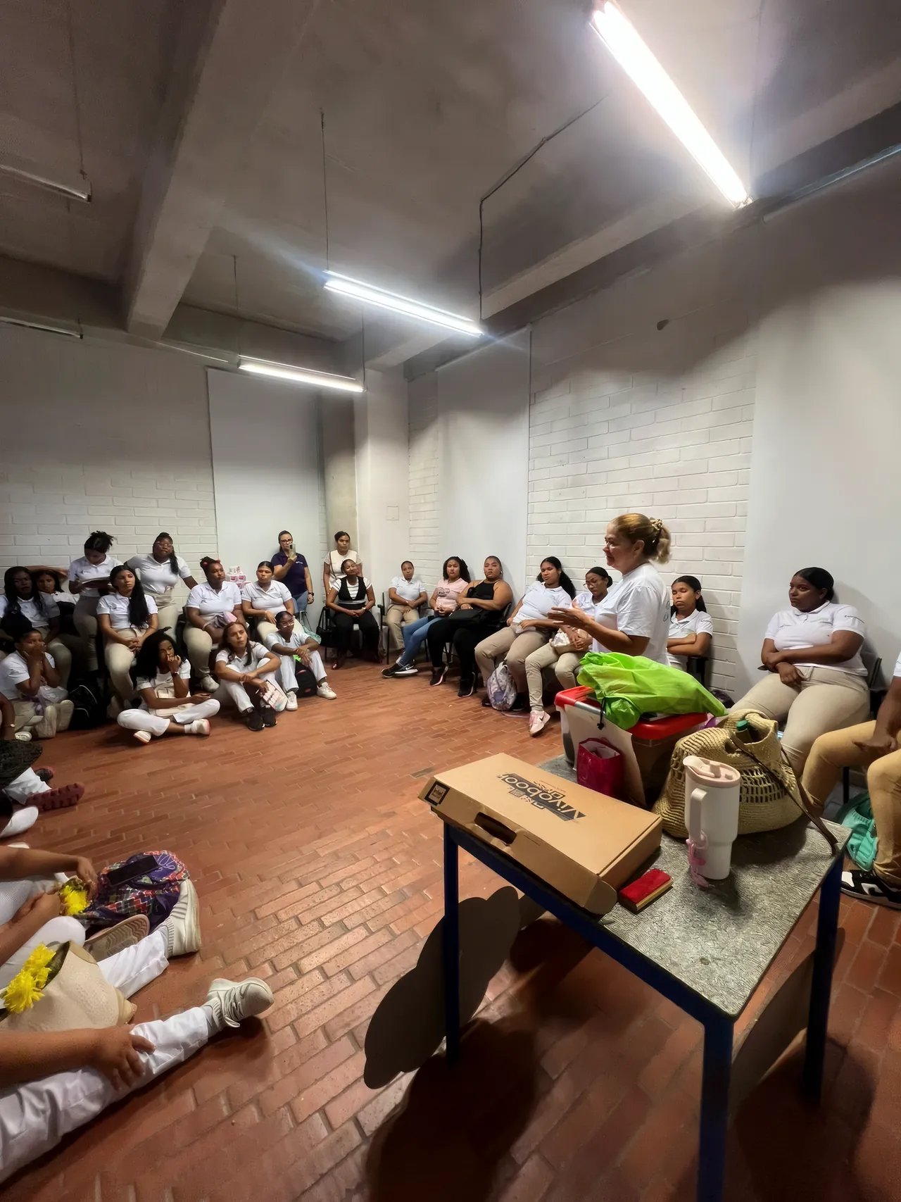 Un grupo grande sentado en círculo en el suelo de un salón