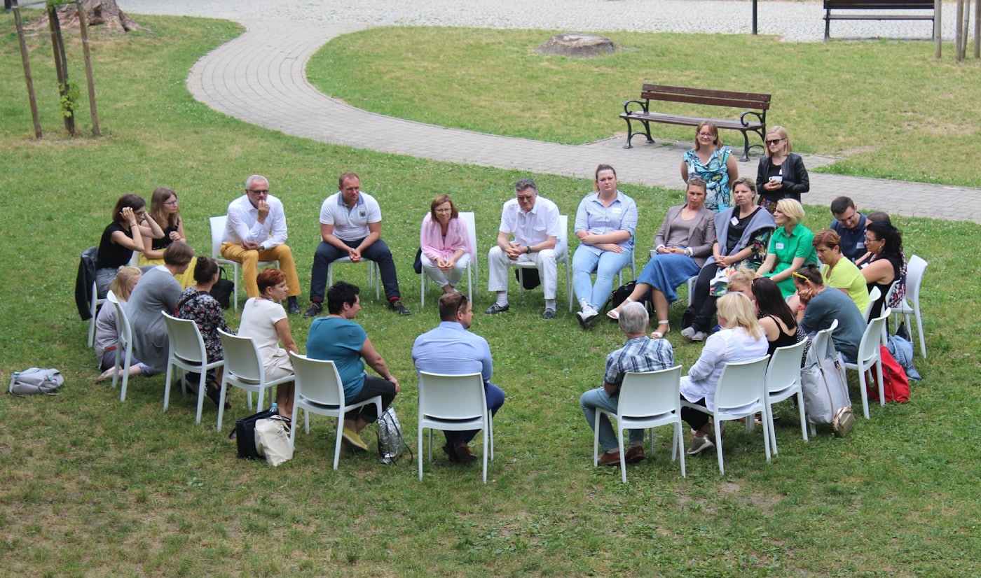Grupo de personas sentadas en círculo en un campo abierto