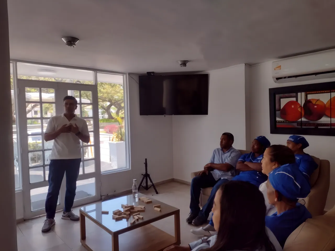 Un facilitador habla de pie a un equipo de trabajo en una sala de reuniones