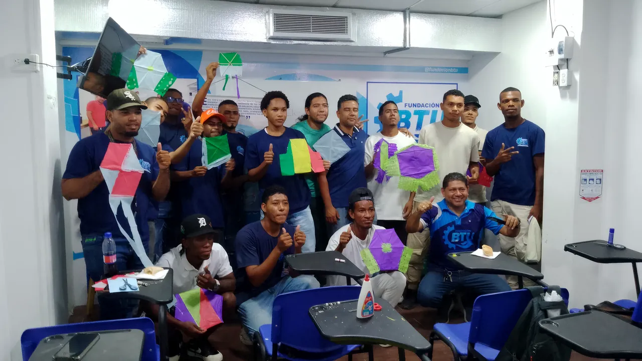 Un grupo de jóvenes muestra en el salón los barriletes de colores que acaba de armar